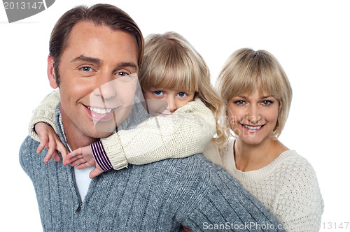 Image of Fun loving family of three, girl piggybacking her father.