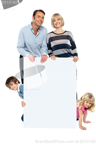 Image of Lively family of four all around blank whiteboard