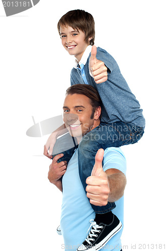 Image of Confident father carrying his son on shoulder