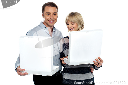 Image of Middle aged couple holding white pizza boxes
