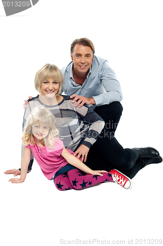 Image of Young family of three posing indoors. Studio shot