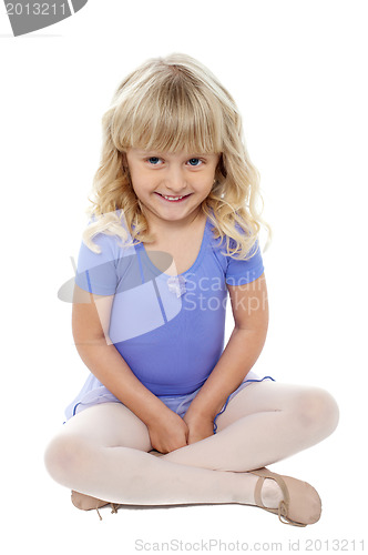 Image of Adorable kid sitting with crossed legs on the floor