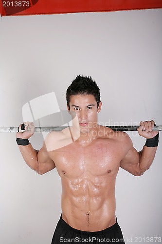 Image of Athletic young man doing workout with weights