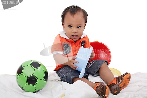 Image of One year old baby boy enjoys playing with toys. Studio Shot. 