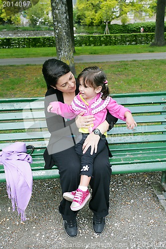 Image of Portrait of smiling mother and little daughter hugging in the pa