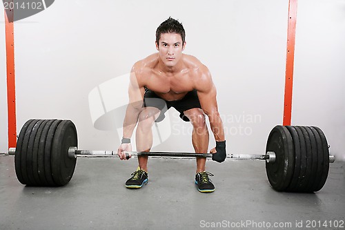 Image of Young and muscular guy holding a barbell.  Crossfit dead lift ex