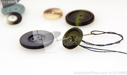 Image of Sew a button with a needle and thread