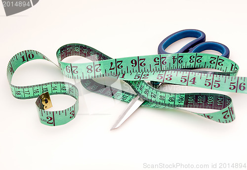 Image of Green measuring tape and scissors 