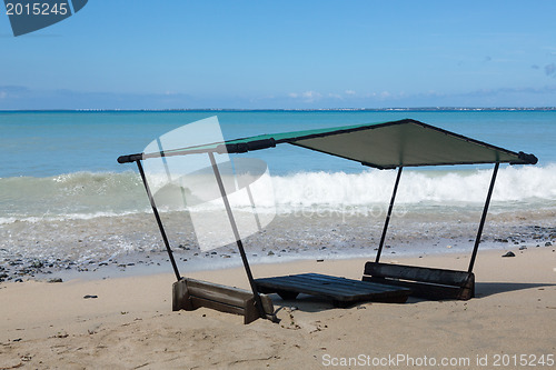 Image of Table and chairs covered by sand on beach