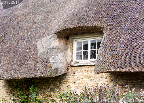 Image of Small wooden window under thatched roof