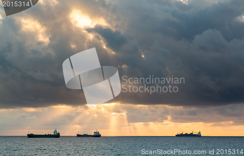 Image of Three cargo freight ships on horizon