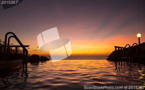 Image of Infinity edge pool with sea underneath sunset