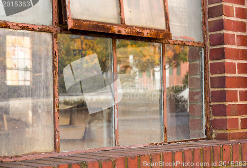 Image of Old rusty window in warehouse reflecting fall