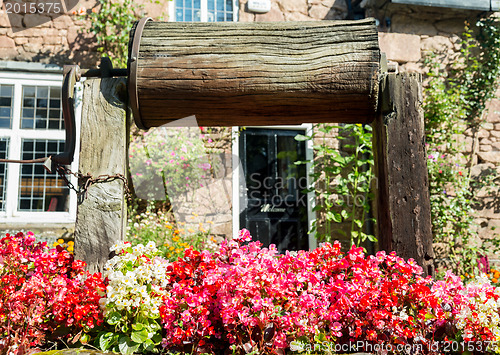 Image of Wooden well winch frames welcome sign