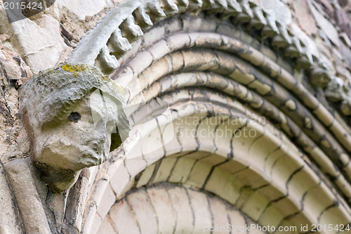 Image of Ancient eroded head of saint on church