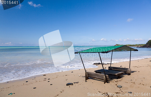 Image of Table and chairs covered by sand on beach