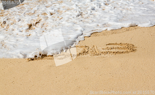 Image of 2013 written in sand with waves