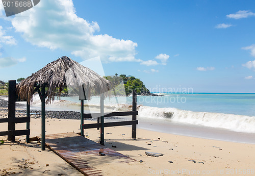 Image of Table and chairs covered by sand on beach