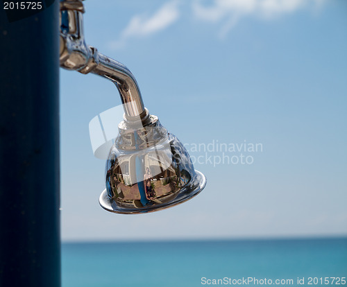 Image of Reflections in beach shower head by ocean