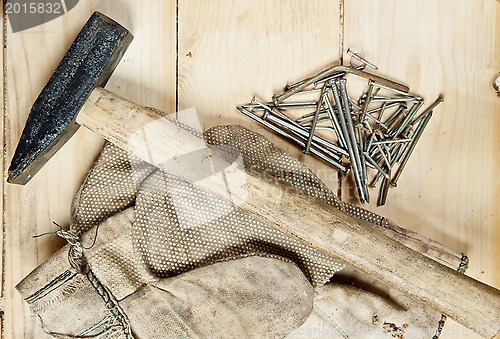 Image of Vintage hammer with nails on wood background