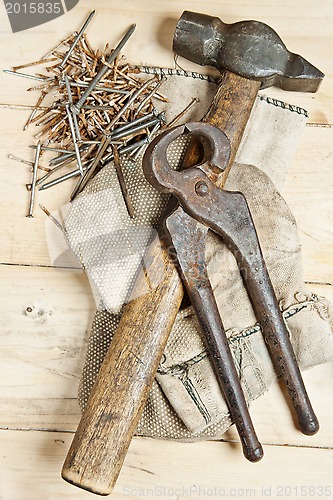 Image of Vintage hammer with nails on wood background