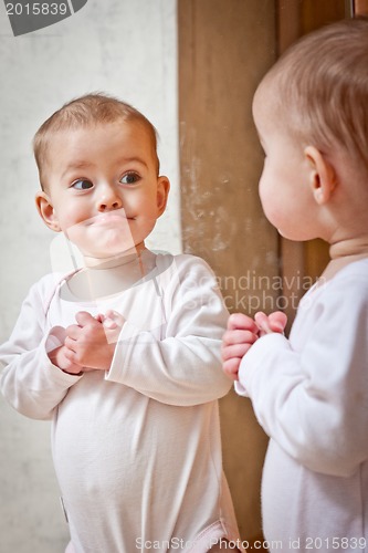 Image of Baby standing against the mirror