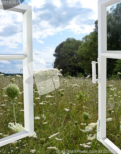 Image of opened window to the summer field