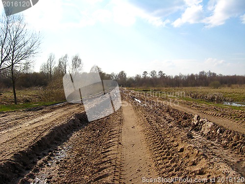 Image of Rural road with greater traces of cars and a dirt