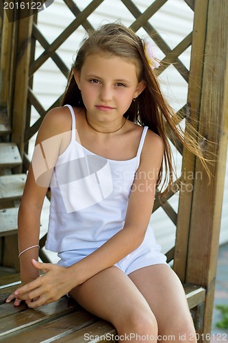 Image of girl sitting on a wooden bench