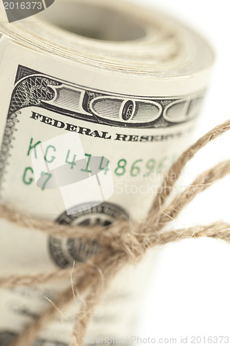 Image of Roll of One Hundred Dollar Bills Tied in Burlap String on White