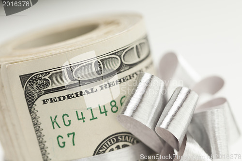 Image of Roll of One Hundred Dollar Bills Tied Silver Bow on White