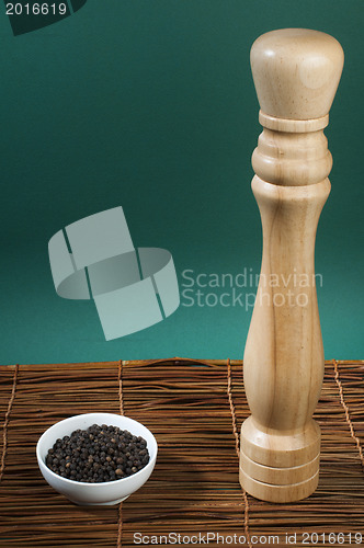 Image of Bowl with black pepper and wooden pepper mill