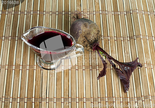 Image of Red beets with leaves and jug with juice