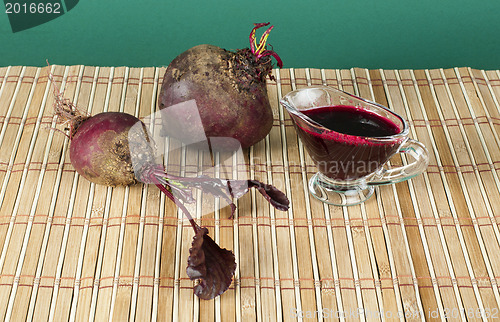 Image of Red beets with leaves and jug with juice