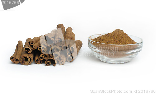 Image of Powdered cinnamon in bowl and cinnamon sticks