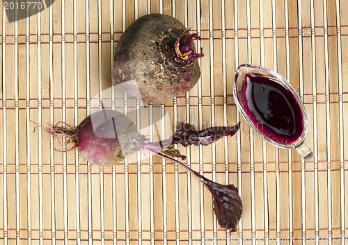 Image of Red beets with leaves and jug with juice