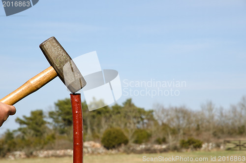 Image of Hammering a pole