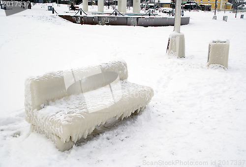 Image of Bench covered with thick coat of ice.
