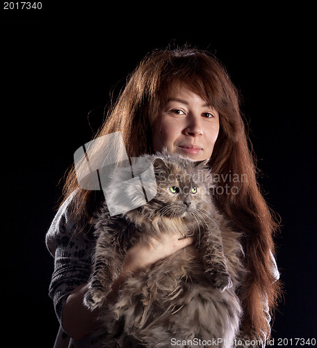 Image of Young beautiful smiling woman holds fluffy cat