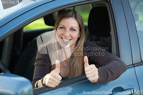 Image of Happy female driver showing thumbs up