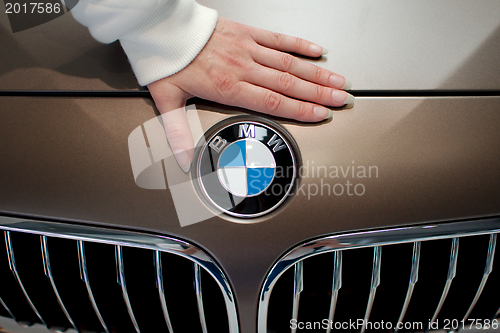 Image of Woman's hand on BMW logo