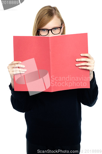 Image of Student with a red book learning intently