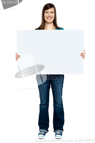 Image of Trendy woman showing blank billboard to camera