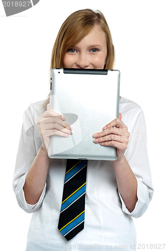 Image of Shy girl hiding her face with a tablet device