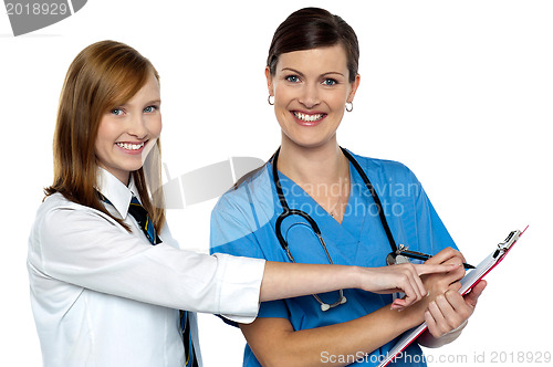 Image of Attractive girl pointing at the doctors case sheet
