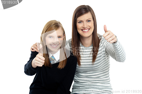 Image of Charming daughter with her mother showing thumbs up sign