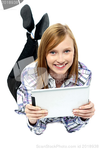 Image of Girl relaxing on studio floor and browsing her new tablet