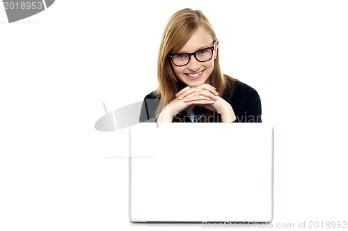 Image of Charming schoolgirl sitting with her laptop open