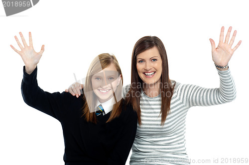 Image of Mum and daughter waving hands at the camera