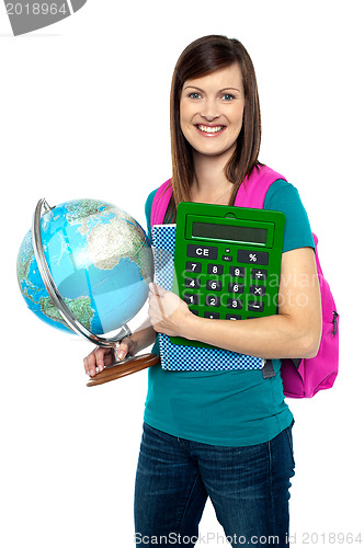 Image of Smiling female student holding a calculator and globe